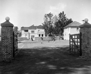 Compound entrance and drive to residence, with offices on the right, 1954.