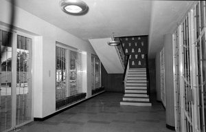 Entrance hall to agency building, with stair up to residence and, at right, door to offices, 1956.